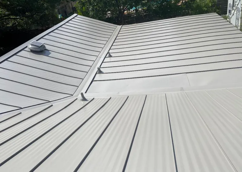 Solar attic fan installed on a metal roof for Roof Ventilation in Glen Cove